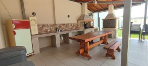 Εξωτερική κουζίνα της Villa Memories στην Κινέτα με BBQ, ξύλινο τραπέζι και σκεπαστό χώρο-2