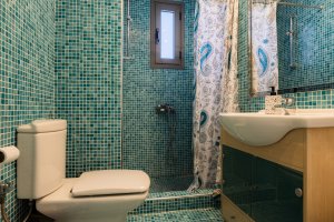 Μπάνιο της Villa Memories στην Κινέτα με ντουζιέρα, νιπτήρα και γαλάζια πλακάκια τοίχου