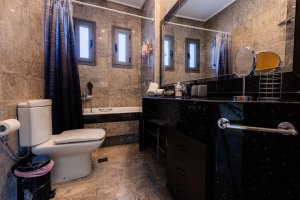 Ευρύχωρο μπάνιο της Villa Memories στην Κινέτα με μπανιέρα, μαρμάρινο πάγκο και καθρέφτη