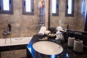 Νιπτήρας μπάνιου της Villa Memories στην Κινέτα με μαύρο μαρμάρινο πάγκο και καθρέφτη