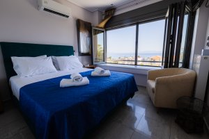 Φωτεινό υπνοδωμάτιο της Villa Memories στην Κινέτα με διπλό κρεβάτι και θέα στη θάλασσα