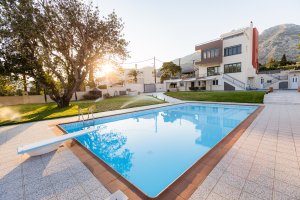 Ιδιωτική πισίνα της Villa Memories με θέα το κτίριο και τον κήπο