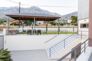 Σκεπασμένος εξωτερικός χώρος της Villa Memories με τραπέζι και καθίσματα