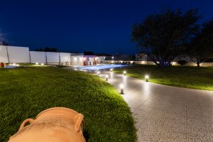 Νυχτερινή άποψη του φωτισμένου κήπου και της πισίνας στη Villa Memories