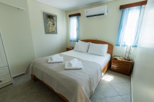 Φωτεινό υπνοδωμάτιο της Villa Memories με διπλό κρεβάτι και λευκά σεντόνια