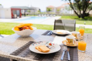 Πρωινό σε εξωτερικό τραπέζι της Villa Memories με φρούτα, χυμό και θέα στην πισίνα