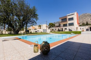 Ιδιωτική πισίνα της Villa Memories στην Κινέτα με θέα την πρόσοψη της βίλας