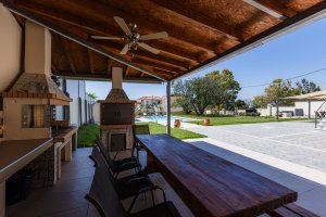 Σκεπασμένος χώρος BBQ στη Villa Memories με ανεμιστήρα οροφής και μεγάλο τραπέζι