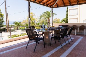 Υπαίθρια τραπεζαρία στη Villa Memories με τραπέζι φαγητού και θέα θάλασσα