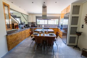 Μεγάλη κουζίνα στη Villa Memories με κεντρική νησίδα και τραπέζι φαγητού